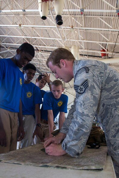 U.S. Air Force Staff Sgt. Douglas Hemmer, 38th Rescue Squadron Survival, Evasion, Resistance and Escape specialist, shows students map coordinates during the Diversity Day Outreach Fair, Sept. 9, 2016, at Moody Air Force Base, Ga. Students were allotted time to visit over 30 Air Force career field booths to see demonstrations and ask open forum questions afterwards. (U.S. Air Force photo by Airman 1st Class Greg Nash)