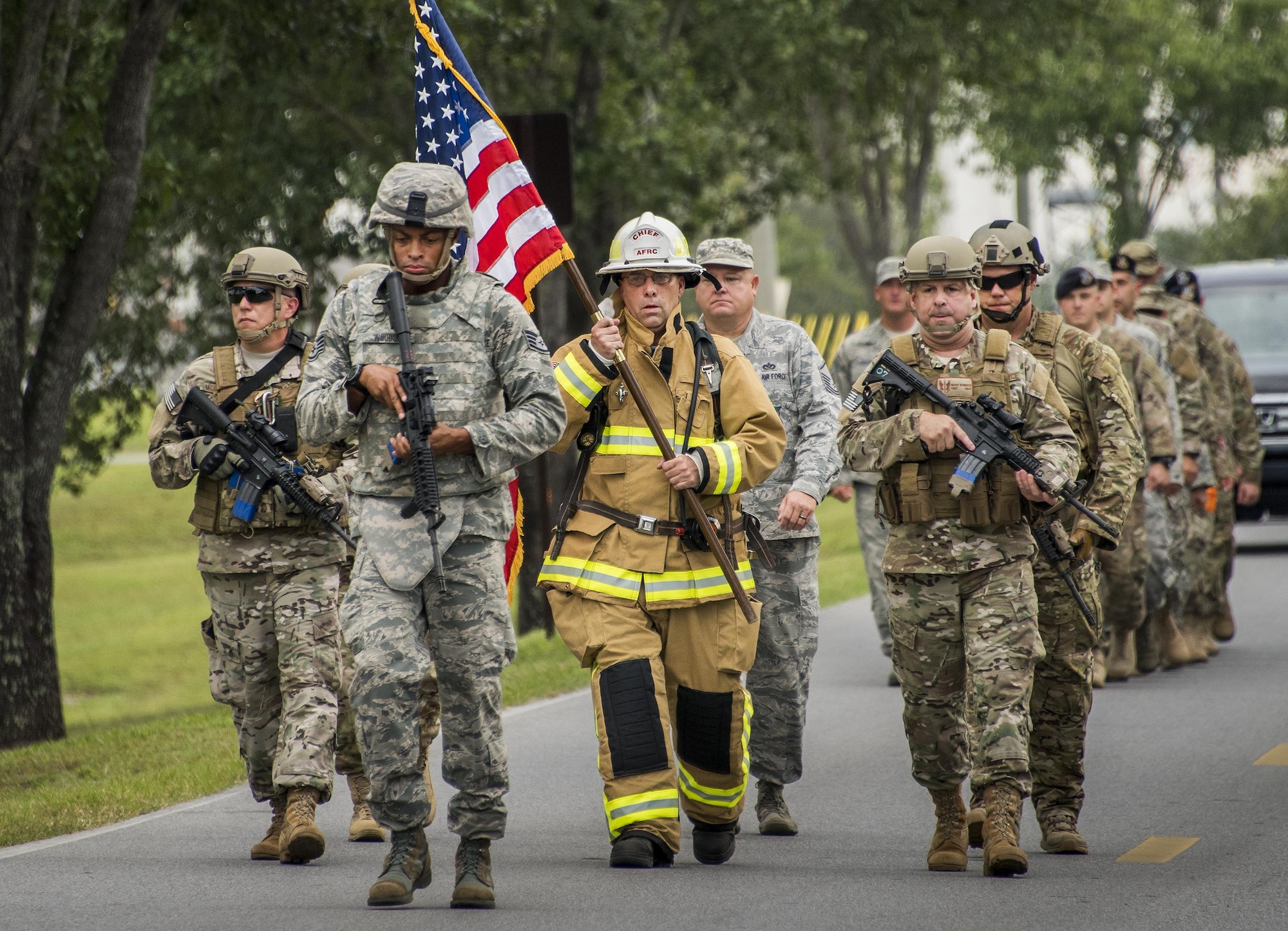 Chief Master Sgt. Pete Webb, 919th Special Operations Wing, carries a flag down the road toward the site of the unit’s 9/11 Memorial Ceremony Sept. 11 at Duke Field, Fla.  The chief was escorted by wing security forces members.  The flag he carried was used during the 24-hour Memorial stair climb event that began the day before.  The stair climb event culminated in the delivery of the flag to the memorial ceremony. (U.S. Air Force photo/Tech. Sgt. Sam King)