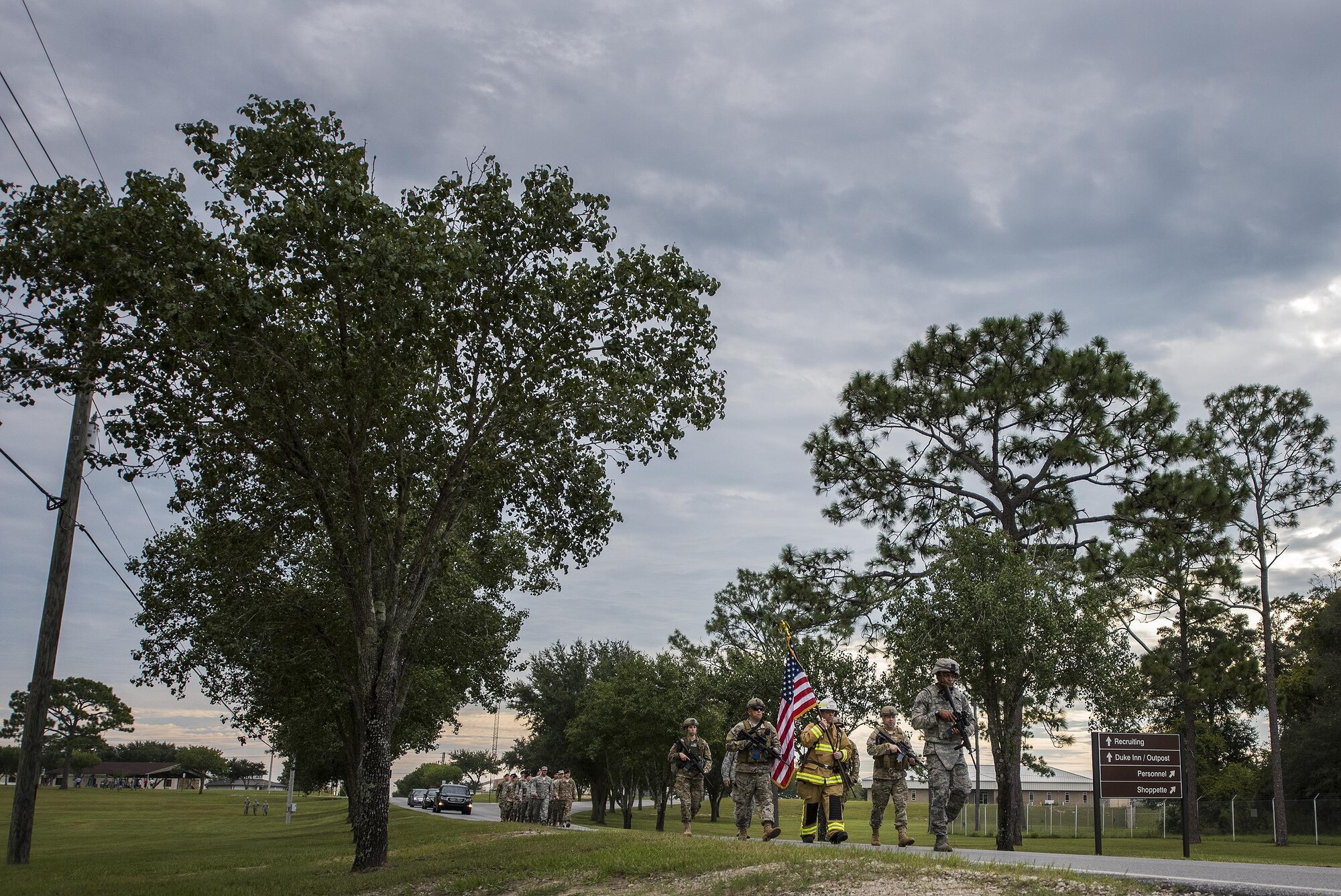 Chief Master Sgt. Pete Webb, 919th Special Operations Wing, carries a flag down the road toward the site of the unit’s 9/11 Memorial Ceremony Sept. 11 at Duke Field, Fla.  The chief was escorted by wing security forces members.  The flag he carried was used during the 24-hour Memorial stair climb event that began the day before.  The stair climb event culminated in the delivery of the flag to the memorial ceremony. (U.S. Air Force photo/Tech. Sgt. Sam King)