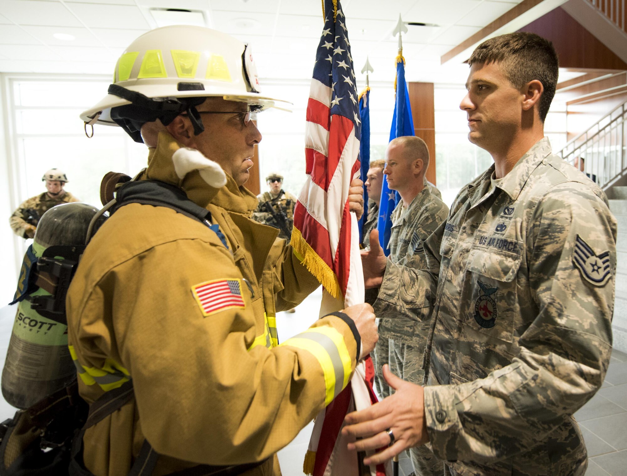 Chief Master Sgt. Pete Webb, 919th Special Operations Wing, hands off the American flag to the color guard detail prior to the 9/11 Memorial Ceremony Sept. 11 at Duke Field, Fla.  The flag used for the ceremony was also used during the 24-hour memorial stair climb event.   (U.S. Air Force photo/Tech. Sgt. Sam King)