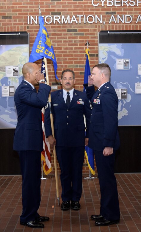 Col. Anthony M. Perkins, 960th Cyberspace Operations Group commander, and Lt. Col. Sam McGlynn, the new 42nd Cyberspace Operations Squadron commander, exchange salutes during an activation ceremony, as Chief Master Sgt. Mark Otzenberger, the squadron's new superintendent stands ready, in the Ludwig Heritage Hall Atrium at Scott Air Force Base, Ill., Sept. 12. McGlynn takes the helm as the squadron's first commander under the new name, and according to Perkins is the right person for the job right now. (U.S. Air Force photo by Maj. Alysia Harvey)