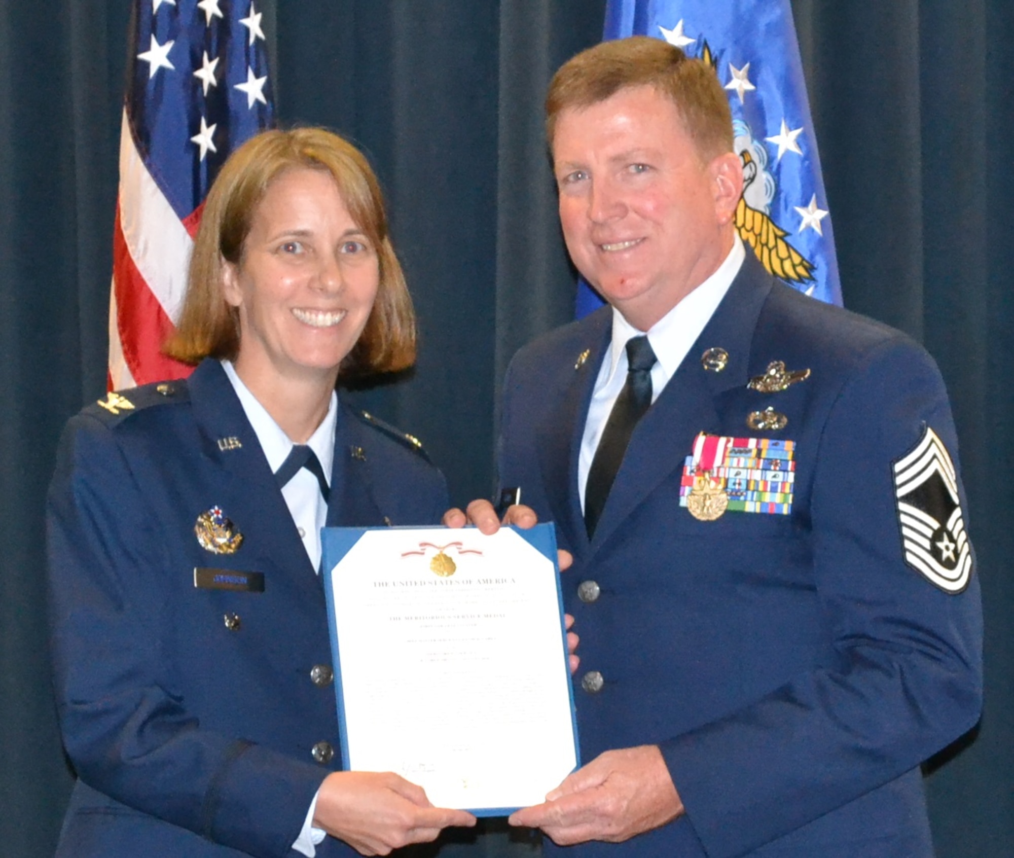 PETERSON AIR FORCE BASE, Colo. – Col. Jennie Johnson presents Chief Master Sgt. David Carey with a Meritorious Service Medal during his retirement ceremony Aug. 6, 2016 here. Carey retired after serving 38 years in the Air Force uniform, spending the majority of his career as an Air Force Reservist with the 302nd Airlift Wing. Carey retired as the flight engineer superintendent with more than 9,500 flight hours in C-130 aircraft. Johnson is the Chief, Total Force Enterprise Division, Headquarters Air Force Air Force Reserve and a former C-130 navigator with the 302nd AW. (U.S. Air Force photo/Lt. Col. Alicia Button)