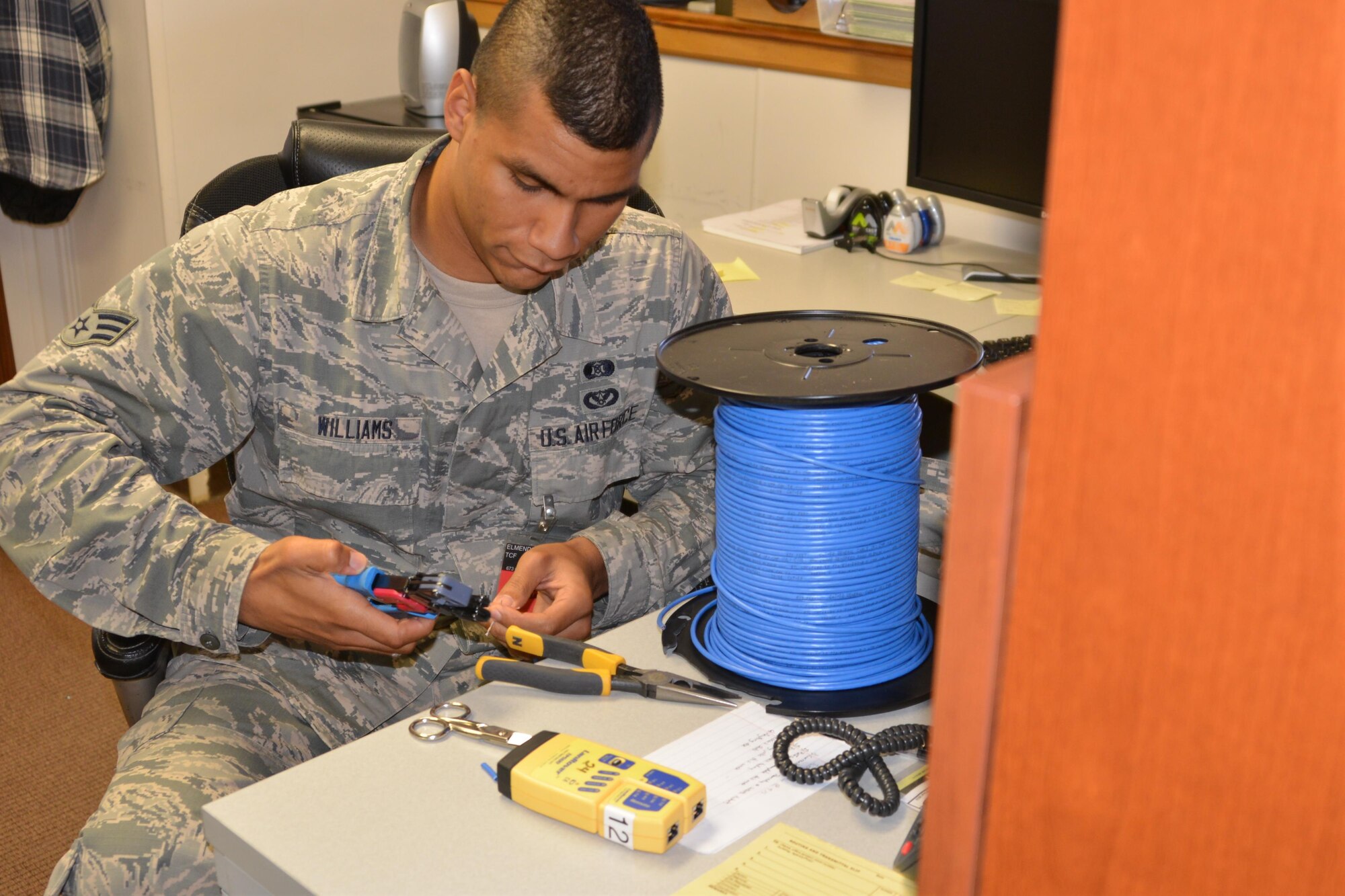 Air Force Senior Airman Demetrius Williams creates cable to enable system repairs during the 477th Fighter Group's Unit Training Assembly Sept. 10, 2016. The Communications Flight ensures the continuous security, operational availability and reliability of systems and equipment supporting the group's mission.