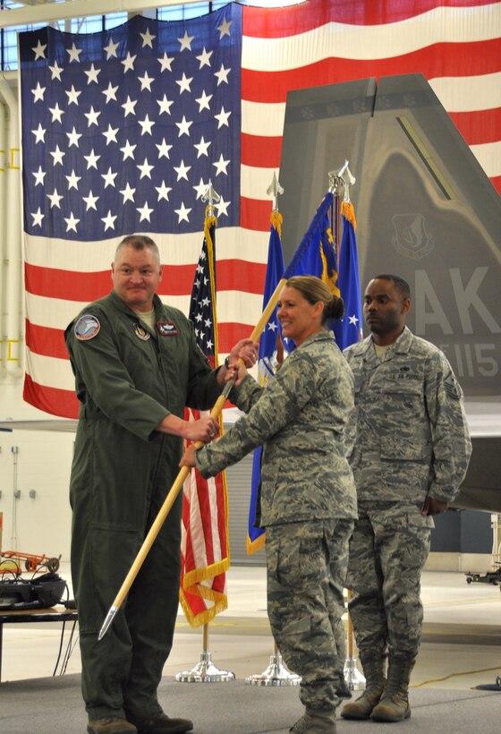 Air Force Col. Christopher Ogren, 477th Fighter Group Commander, presents the 477th Aircraft Maintenance Squadron colors to Maj. Rebecca Daugherty, the new 477th AMXS Commander, during an assumption of command ceremony at Joint Base Elmendorf-Richardson Sept. 11, 2016. (U.S. Air Force photo/Maj. Carla Gleason)