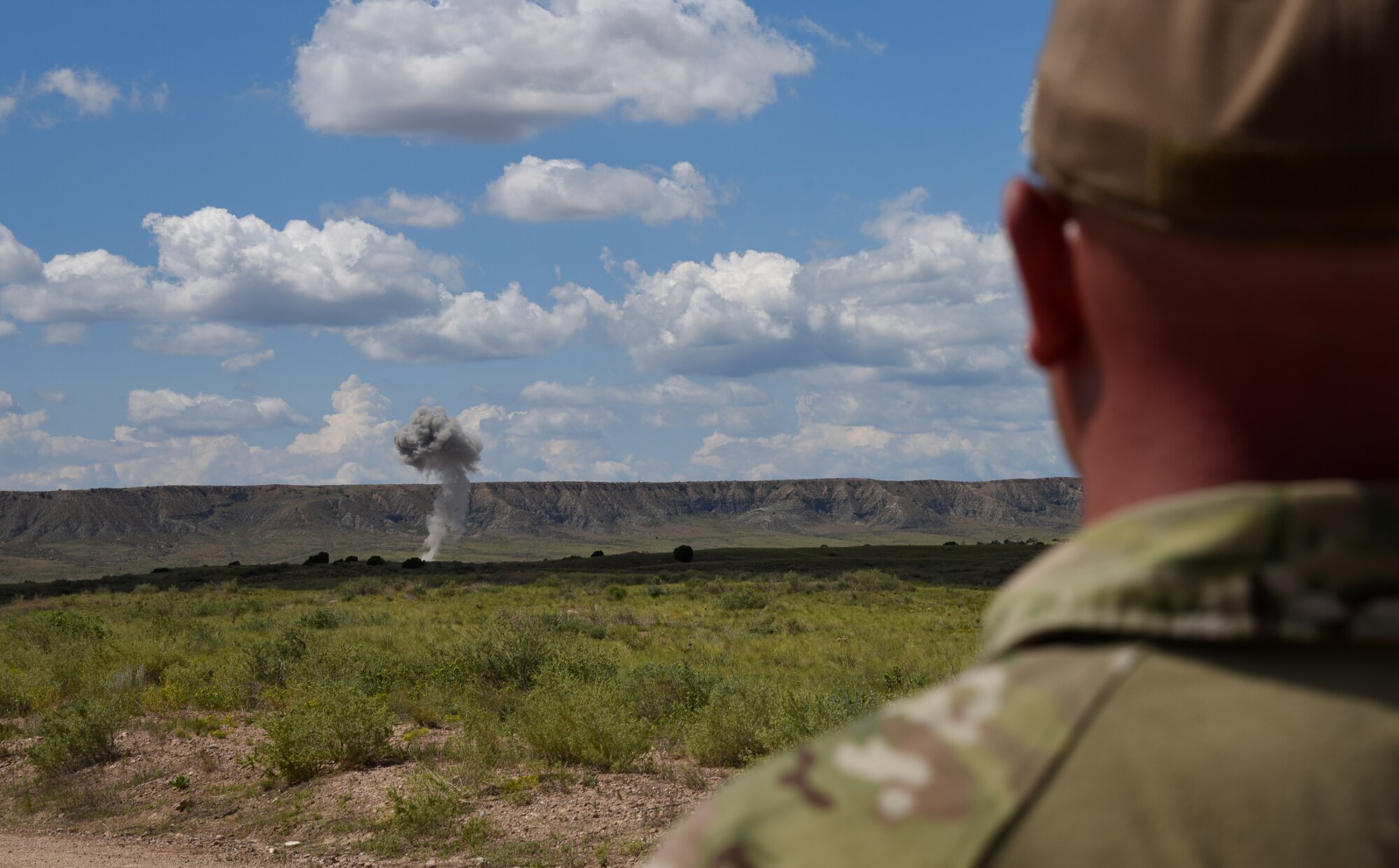 FORT CARSON, Colo. – A 302nd Civil Engineer Squadron Explosive Ordnance Disposal technician watches as explosives detonate during a live, mass-demolition training operation at the bombing range on Fort Carson, Colo., Aug 31, 2016. The closest anyone could view the explosion safely was approximately two miles from the blast site. (U.S. Air Force photo by Airman 1st Class Dennis Hoffman) 