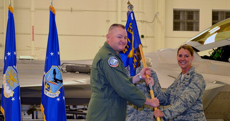 Air Force Col. Christopher Ogren, 477th Fighter Group Commander, presents the 477th Aircraft Maintenance Squadron colors to Maj. Rebecca Daugherty, the new 477th AMXS Commander, during an assumption of command ceremony at Joint Base Elmendorf-Richardson Sept. 11, 2016. (U.S. Air Force photo/Maj. Carla Gleason)