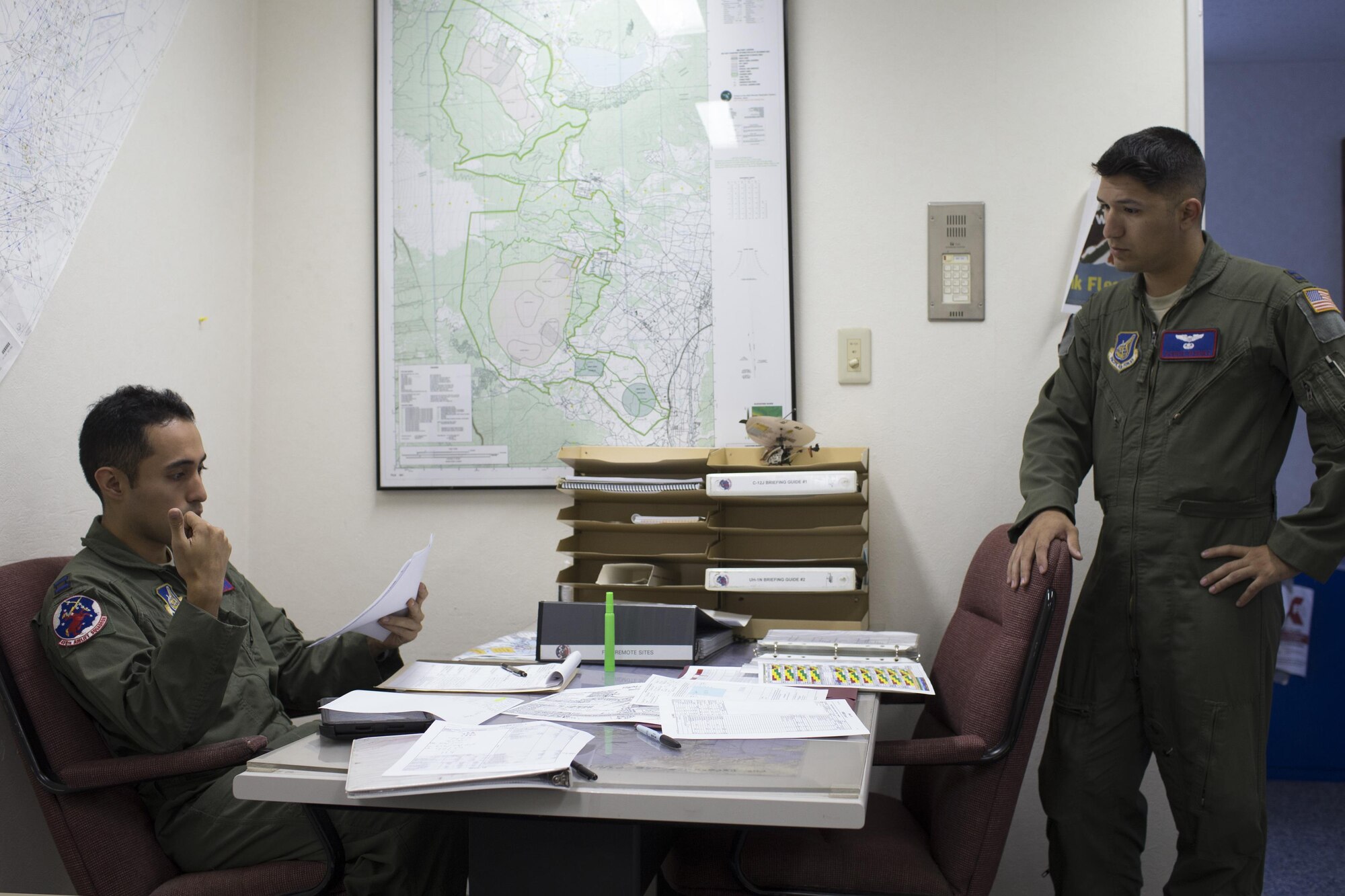 (Left to right) Capt. Jonathan Bonilla and Capt. Vicente Vasquez, 459th Airlift Squadron UH-1N Iroquois pilots, discuss planned routes on a map during a pre-flight briefing at Yokota Air Base, Japan, Sept. 4, 2016. Airmen with the 459 AS delivered simulated disaster relief supplies to the Tokyo Rinkai Disaster Prevention Park during the Annual Tokyo Metropolitan Government Disaster Management Drill. The park is located in the Ariake area and is a disaster countermeasure headquarters of the Government of Japan and other local governments during large-scale earthquakes in the metropolitan area. (U.S. Air Force photo by Yasuo Osakabe/Released) 