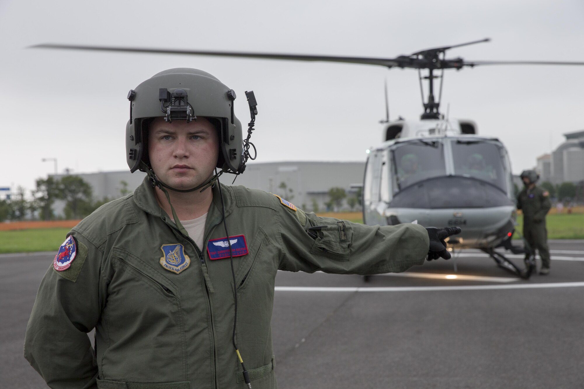 Tech. Sgt. Christopher Rector, 459th Airlift Squadron flight engineer, gives a hand signal to his crewmembers during the Annual Tokyo Metropolitan Government Disaster Management Drill at Tokyo Rinkai Disaster Prevention Park, Japan, Sept. 4, 2016. The park is located in the Ariake area and is a disaster countermeasure headquarters of the Government of Japan and other local governments during large-scale earthquakes in the metropolitan area. Every year, members of Yokota practice emergency drills with the Government of Japan to prepare for potential natural disaster emergencies. (U.S. Air Force photo by Yasuo Osakabe/Released)    