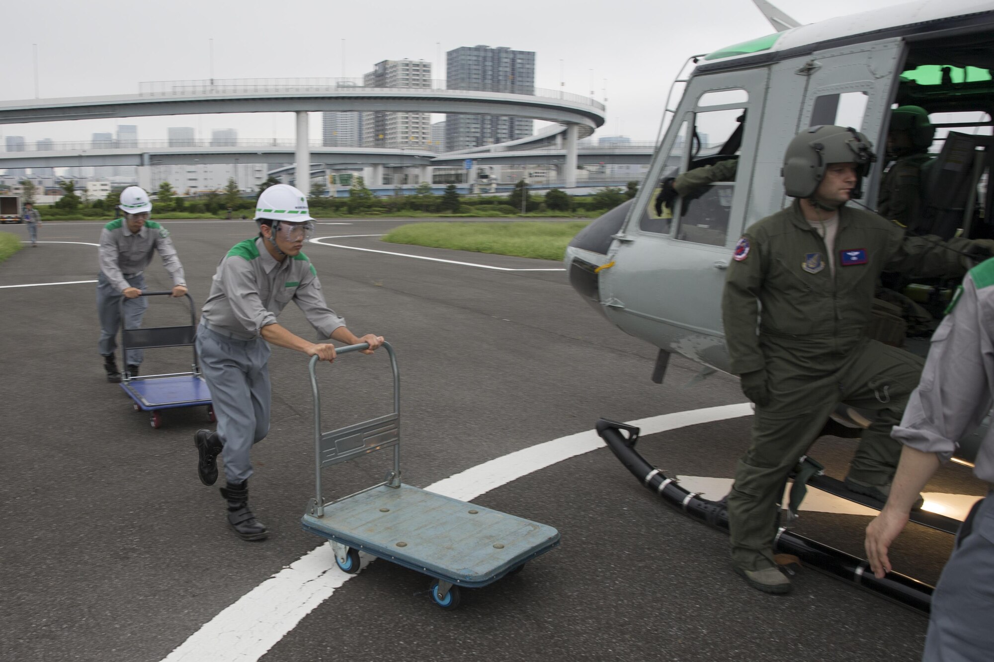 Members with the Tokyo Metropolitan Government pick up simulated relief supplies at Tokyo Rinkai Disaster Prevention Park, Japan, Sept. 4, 2016, during the Annual Tokyo Metropolitan Government Disaster Management Drill. Airmen with the 459 AS practiced delivering simulated relief supplies to Tokyo Rinkai Disaster Prevention Park in downtown Tokyo. The park is located in the Ariake area and is a disaster countermeasure headquarters of the Government of Japan and other local governments during large-scale earthquakes in the metropolitan area. (U.S. Air Force photo by Yasuo Osakabe/Released)    