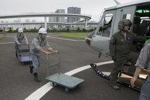Members with the Tokyo Metropolitan Government pick up simulated relief supplies at Tokyo Rinkai Disaster Prevention Park, Japan, Sept. 4, 2016, during the Annual Tokyo Metropolitan Government Disaster Management Drill. Airmen with the 459 AS practiced delivering simulated relief supplies to Tokyo Rinkai Disaster Prevention Park in downtown Tokyo. The park is located in the Ariake area and is a disaster countermeasure headquarters of the Government of Japan and other local governments during large-scale earthquakes in the metropolitan area. (U.S. Air Force photo by Yasuo Osakabe/Released)    