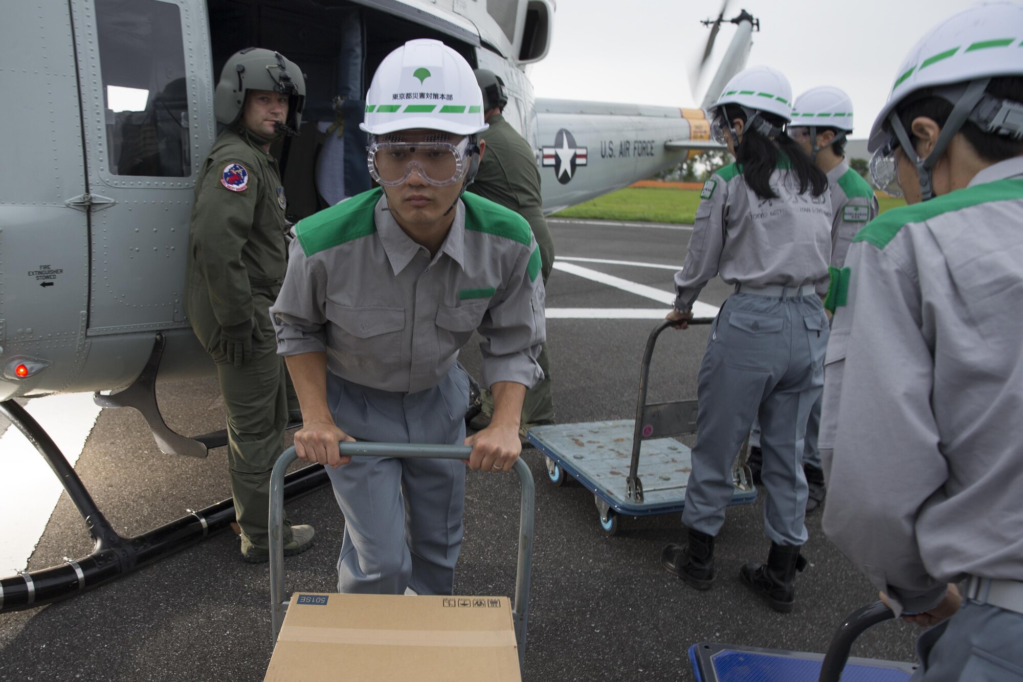 Members with the Tokyo Metropolitan Government pick up simulated relief supplies at Tokyo Rinkai Disaster Prevention Park, Japan, Sept. 4, 2016, during the Annual Tokyo Metropolitan Government Disaster Management Drill. Airmen with the 459 AS practiced delivering simulated relief supplies to Tokyo Rinkai Disaster Prevention Park in downtown Tokyo. The park is located in the Ariake area and is a disaster countermeasure headquarters of the Government of Japan and other local governments during large-scale earthquakes in the metropolitan area. (U.S. Air Force photo by Yasuo Osakabe/Released)    