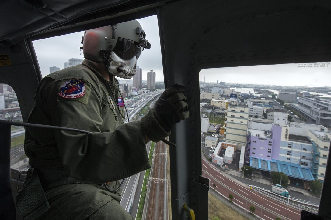 Tech. Sgt. Christopher Rector, 459th Airlift Squadron flight engineer, performs visual conformation over Shibaura, Japan, Sept. 4, 2016, during the Annual Tokyo Metropolitan Government Disaster Management Drill. Airmen with the 459 AS practiced delivering simulated relief supplies to Tokyo Rinkai Disaster Prevention Park in downtown Tokyo. The park is located in the Ariake area and is a disaster countermeasure headquarters of the Government of Japan and other local governments during large-scale earthquakes in the metropolitan area. (U.S. Air Force photo by Yasuo Osakabe/Released) 