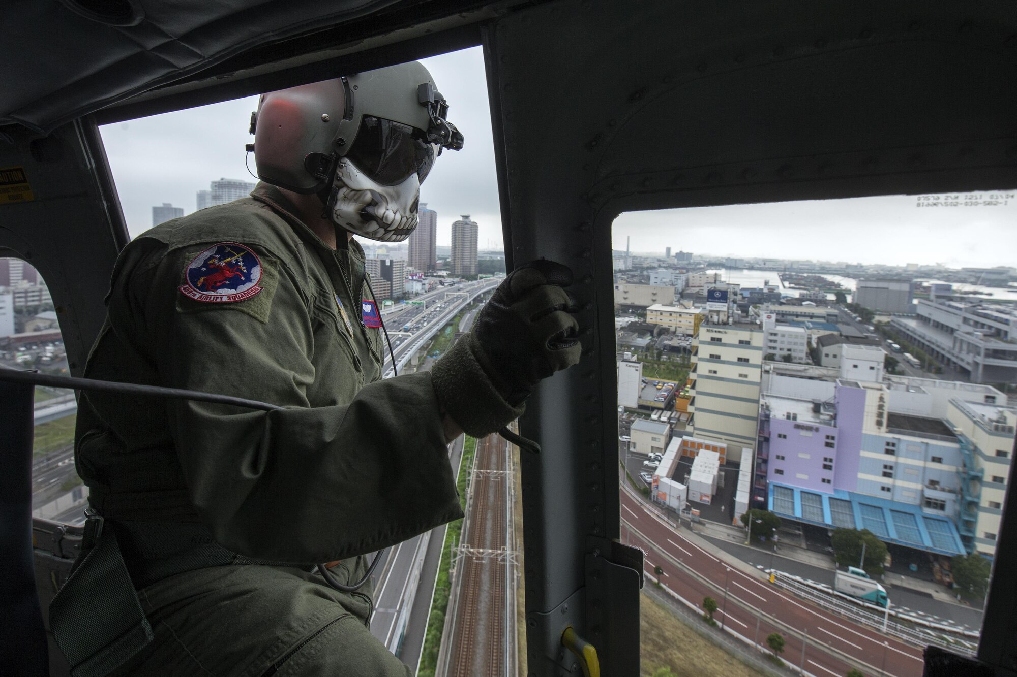 Tech. Sgt. Christopher Rector, 459th Airlift Squadron flight engineer, performs visual conformation over Shibaura, Japan, Sept. 4, 2016, during the Annual Tokyo Metropolitan Government Disaster Management Drill. Airmen with the 459 AS practiced delivering simulated relief supplies to Tokyo Rinkai Disaster Prevention Park in downtown Tokyo. The park is located in the Ariake area and is a disaster countermeasure headquarters of the Government of Japan and other local governments during large-scale earthquakes in the metropolitan area. (U.S. Air Force photo by Yasuo Osakabe/Released) 