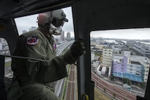 Tech. Sgt. Christopher Rector, 459th Airlift Squadron flight engineer, performs visual conformation over Shibaura, Japan, Sept. 4, 2016, during the Annual Tokyo Metropolitan Government Disaster Management Drill. Airmen with the 459 AS practiced delivering simulated relief supplies to Tokyo Rinkai Disaster Prevention Park in downtown Tokyo. The park is located in the Ariake area and is a disaster countermeasure headquarters of the Government of Japan and other local governments during large-scale earthquakes in the metropolitan area. (U.S. Air Force photo by Yasuo Osakabe/Released) 