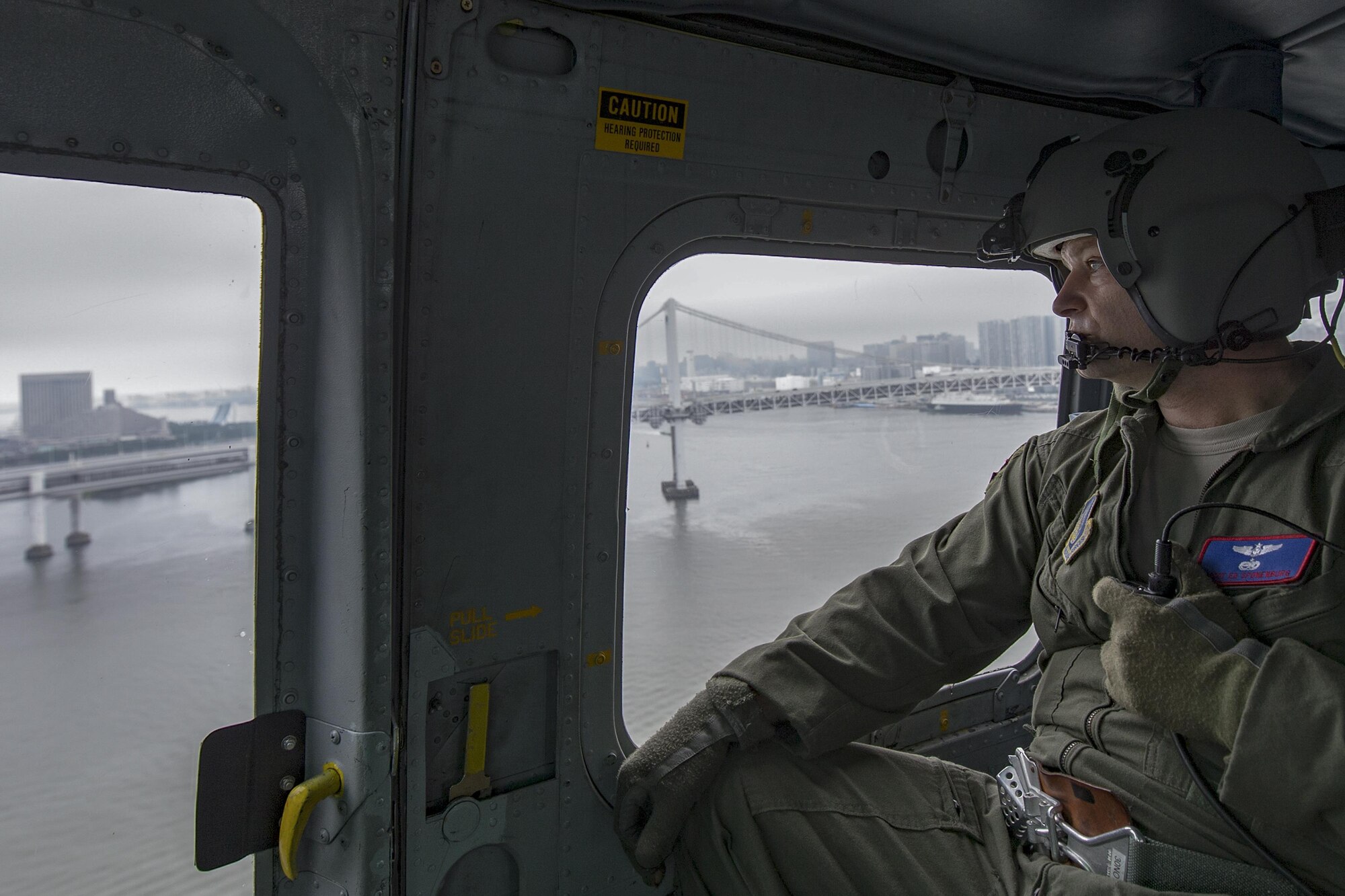 Senior Master Sgt. Edward Sponenburg, 459th Airlift Squadron flight engineer, communicates with UH-1N crewmembers over the Tokyo Bay, Japan, Sept. 4, 2016. Airmen with the 459 AS delivered simulated disaster relief supplies to the Tokyo Rinkai Disaster Prevention Park during annual Tokyo Metropolitan Government Disaster Management Drill. The park is located in the Ariake area and is a disaster countermeasure headquarters of the Government of Japan and other local governments during large-scale earthquakes in the metropolitan area. (U.S. Air Force photo by Yasuo Osakabe/Released)  