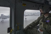 Senior Master Sgt. Edward Sponenburg, 459th Airlift Squadron flight engineer, communicates with UH-1N crewmembers over the Tokyo Bay, Japan, Sept. 4, 2016. Airmen with the 459 AS delivered simulated disaster relief supplies to the Tokyo Rinkai Disaster Prevention Park during annual Tokyo Metropolitan Government Disaster Management Drill. The park is located in the Ariake area and is a disaster countermeasure headquarters of the Government of Japan and other local governments during large-scale earthquakes in the metropolitan area. (U.S. Air Force photo by Yasuo Osakabe/Released)  