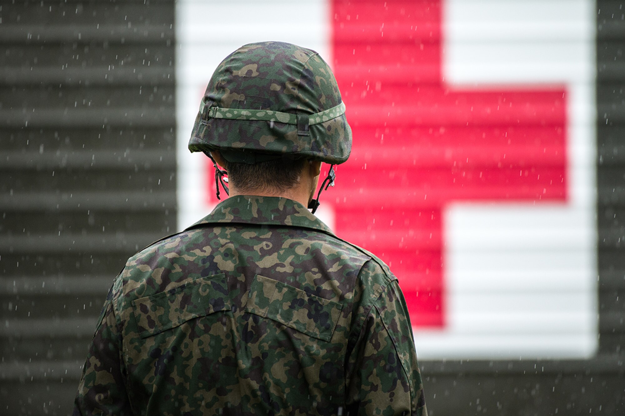 A Japan Ground Self-Defense Force soldier watches as a medical vehicle passes by during the Kanagawa Prefecture Government Joint Disaster Drill at JGSDF Camp Takeyama, Japan, Sept. 11, 2016. Throughout the exercise, U.S. Armed Forces and Japan Self-Defense Force members practiced providing on-sight medical relief to simulated victims of various natural disasters. (U.S. Air Force photo by Senior Airman Delano Scott/Released)