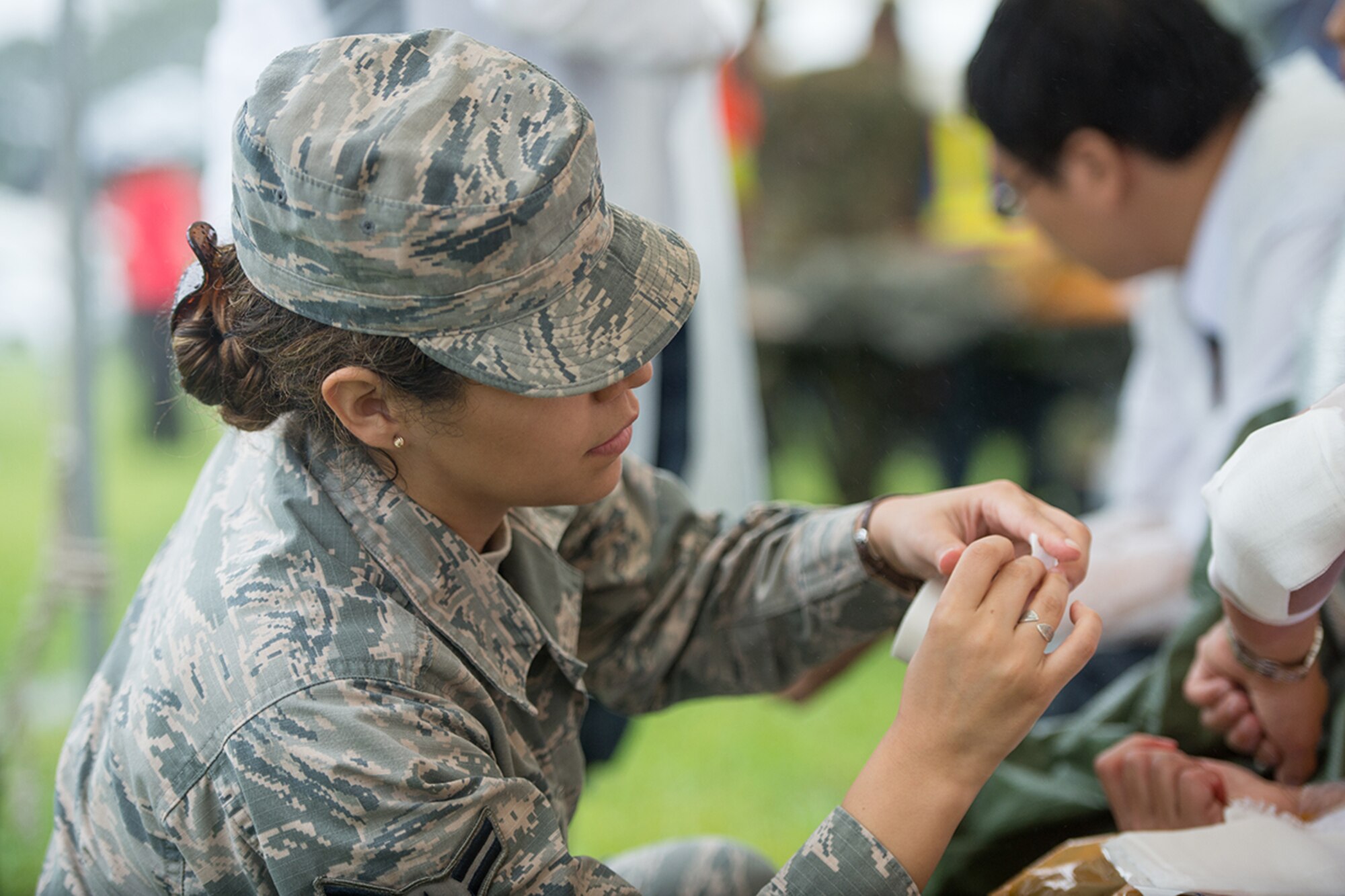 Airman 1st Class Samantha Trevino, 374th Aerospace Medicine Squadron medicine technician, treats the injuries of a simulated patient during the Kanagawa Prefecture Government Joint Disaster Drill at Japan Ground Self-Defense Force Camp Takeyama, Japan, Sept. 11, 2016. Yokota Airmen have participated in the drill since 2014 in an effort to enhance emergency response capabilities with the Japan Self-Defense Force and local Japanese emergency response organizations. (U.S. Air Force photo by Senior Airman Delano Scott/Released)
