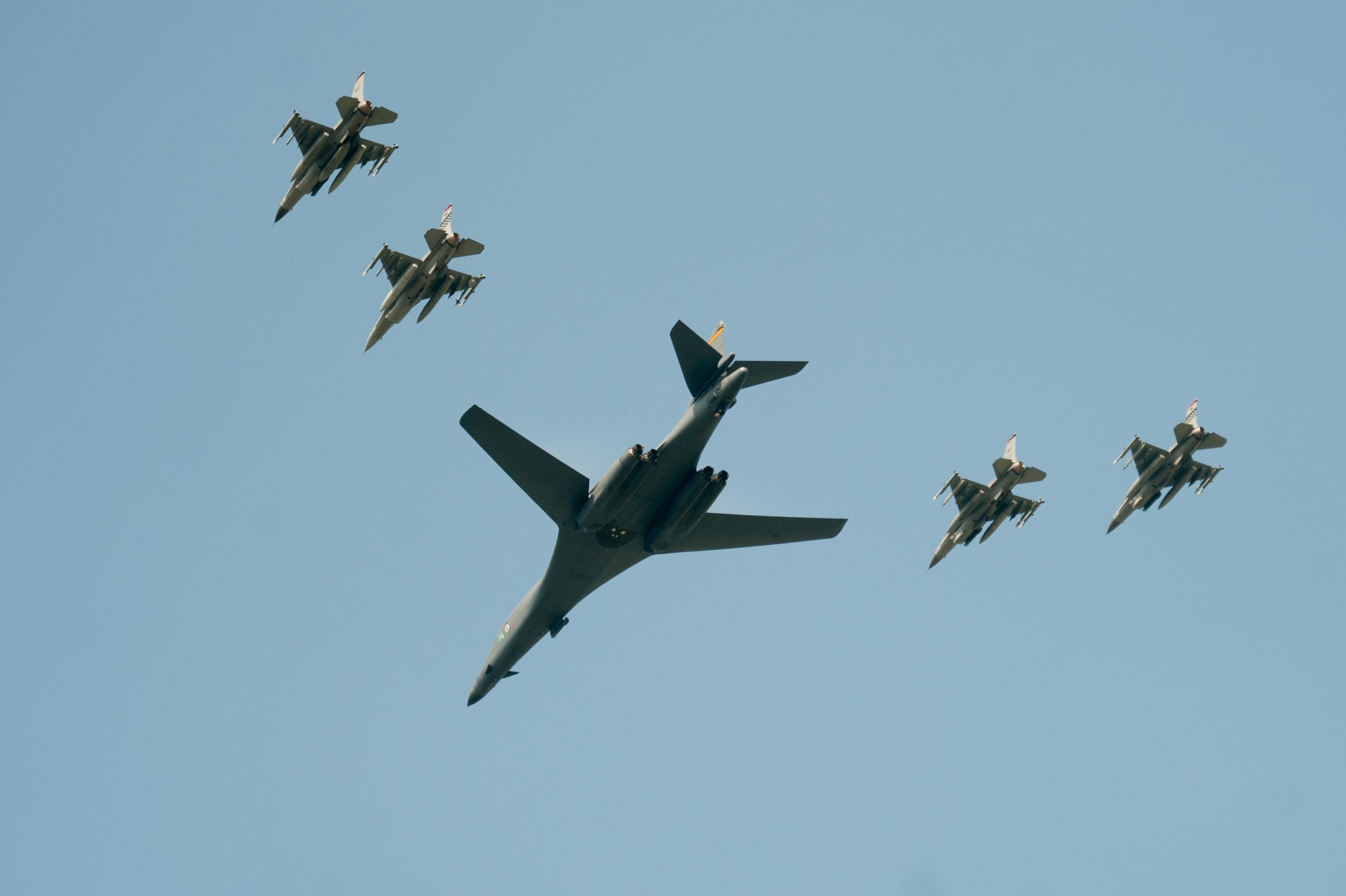 A U.S. Air Force B-1B Lancer, escorted by U.S. Air Force F-16 Fighting Falcons, performs a flyover over Osan Air Base, ROK, Sept. 13, 2016. The flyover highlighted the close cooperation between American and ROK military forces that keeps them ready to respond at any time to threats to stability and security. The B-1s are currently assigned to Andersen Air Force Base, Guam. (U.S. Air Force photo by SSgt Jonathan Steffen) 