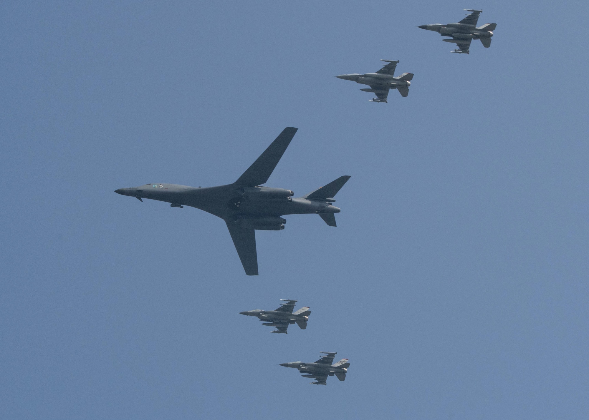 U.S. Air Force F-16 Fighting Falcons assigned to the 36th Fighter Squadron escort a U.S. Air Force B-1B Lancer from Andersen Air Force Base, Guam, during a flyover over Osan Air Base, Republic of Korea, Sept. 13, 2016. The B-1 is capable of rapidly delivering massive quantities of precision and non-precision weapons against any adversary, anywhere in the world, at any time. (U.S. Air Force photo by Victor J. Caputo)