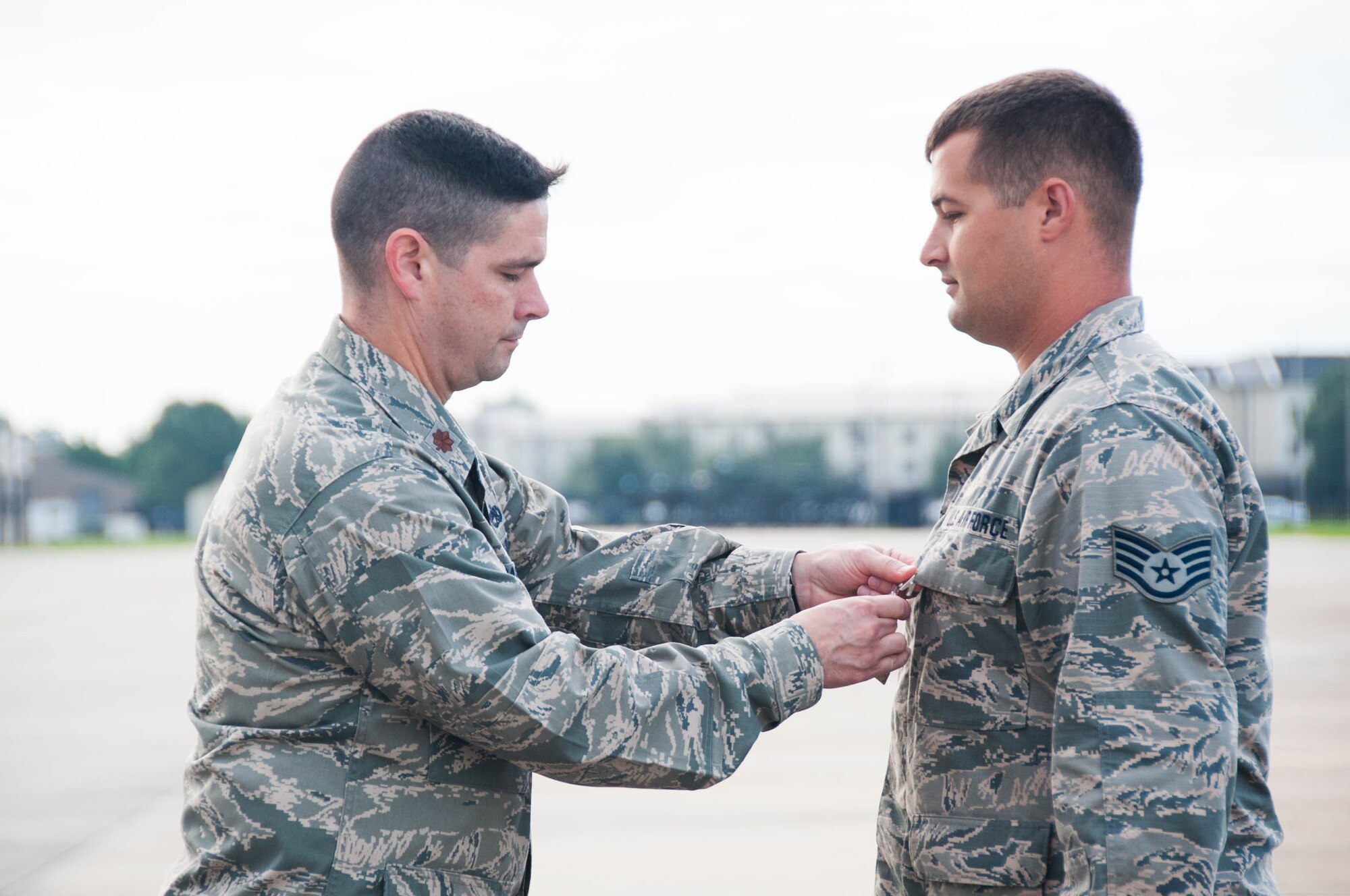 Maj. Quinton Sasnett, 403rd Maintenance Squadron commander, pins an Air Force Commendation medal on Staff Sgt. Christopher Simmons, 403rd MXS maintainer, Sept. 11 at Keesler Air Force Base, Mississippi. Simmons received the medal for helping evacuate more than 600 inmates and guards from Escambia County Jail after an explosion and also preventing a secondary explosion there in 2014.(U.S. Air Force photo/Senior Airman Heather Heiney) 