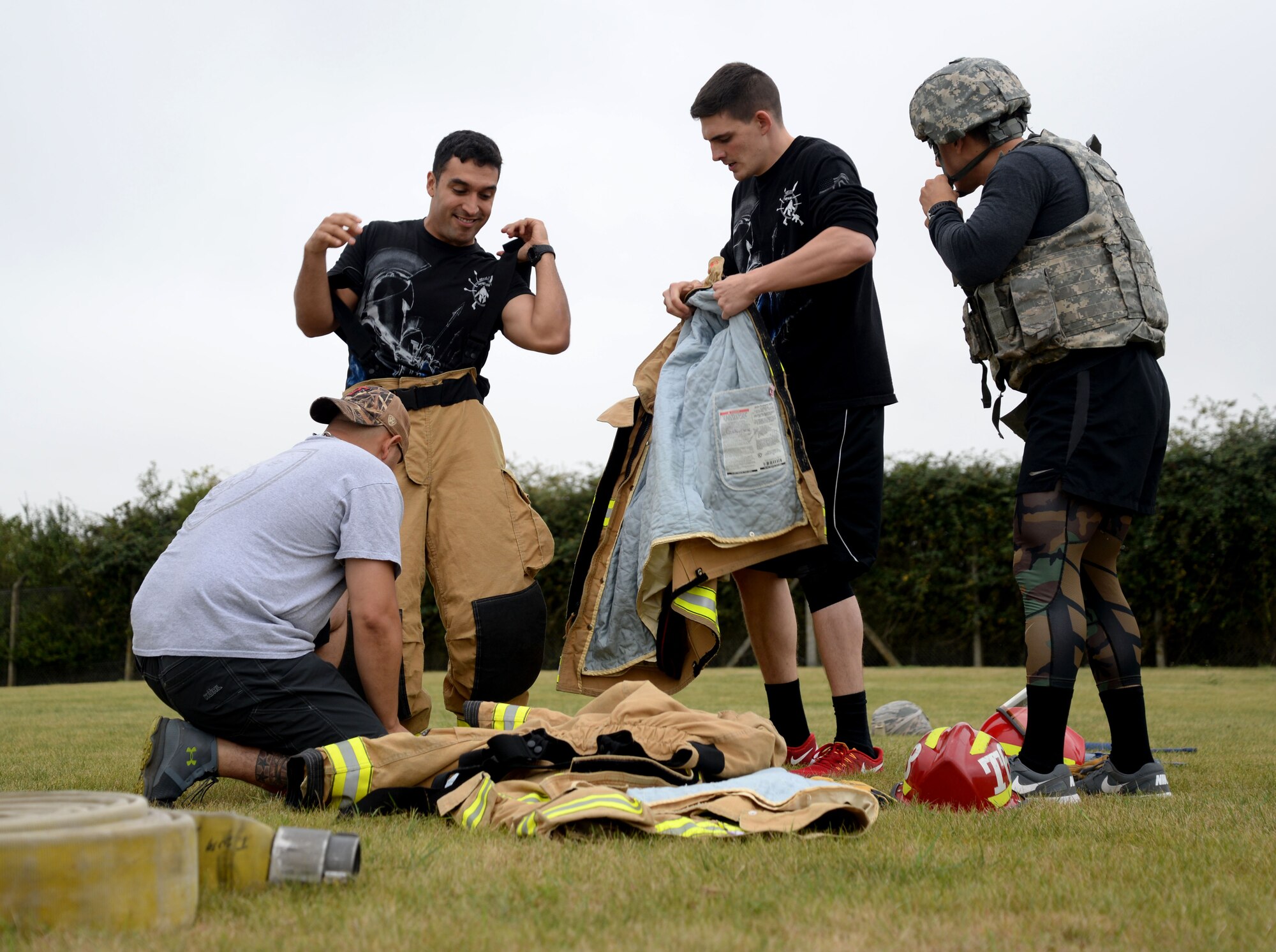 A team of firefighters and defenders from the 48th Civil Engineer Squadron and the 48th Security Forces Squadron from RAF Lakenheath, scramble to get into each other’s first-responder uniforms before performing various maneuvers Sept. 7, 2016, on RAF Mildenhall, England. RAF Mildenhall’s team, comprising 100th CES firefighters and 100th SFS defenders, raced against their neighboring base counterparts during the “Battle of the Badges.” The relay also involved a handcuffed M-16 assembly, a litter carry and a firehose challenge. (U.S. Air Force photo by Senior Airman Justine Rho)  