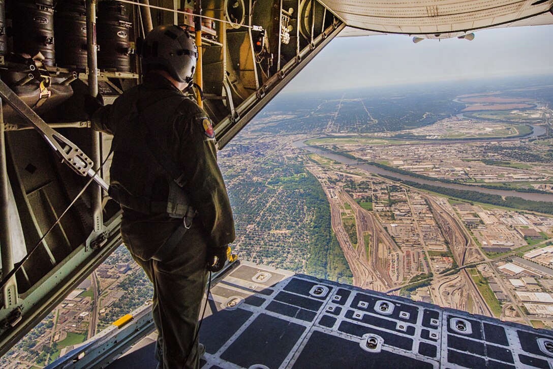 An airman looks out the back of a C-130 Hercules aircraft for clearance before the U.S. Navy Parachute Demonstration Team, the Leap Frogs, jump into Arrowhead Stadium for the Kansas City Chiefs versus San Diego Chargers salute to service members football game in Kansas City, Missouri, Sept. 11, 2016. Air National Guard photo by Senior Airman Sheldon Thompson