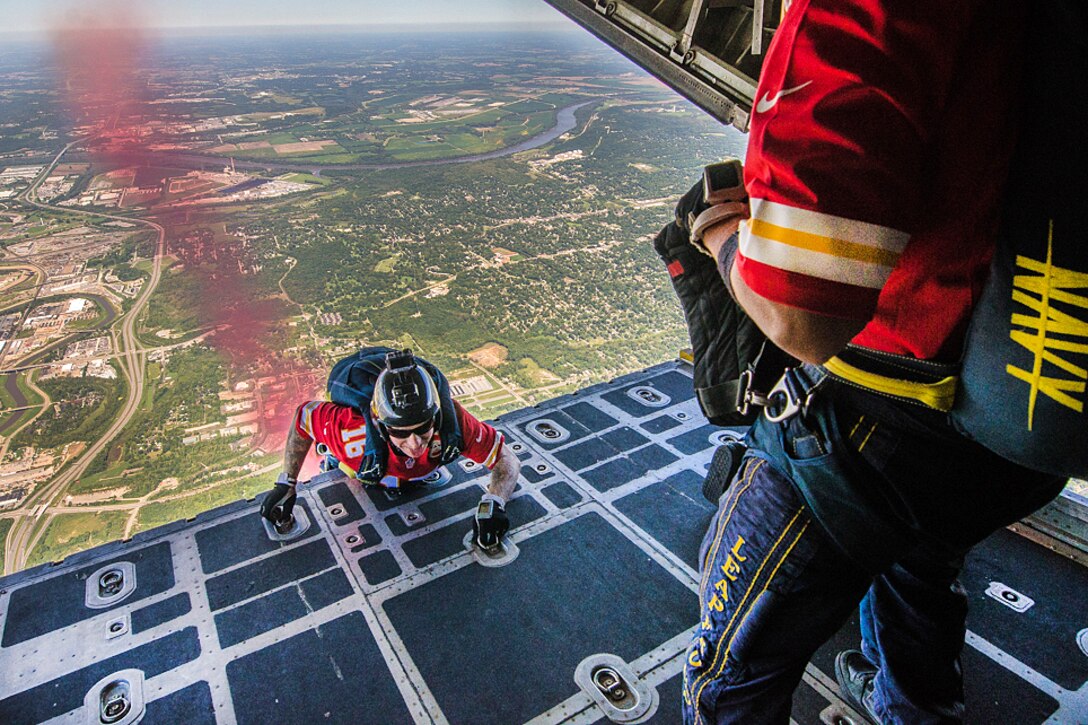 Members of the U.S. Navy Parachute Demonstration Team, the Leap Frogs, jump out of a C-130 Hercules aircraft into Arrowhead Stadium for the Kansas City Chiefs versus San Diego Chargers salute to service members football game in Kansas City, Missouri, Sept. 11, 2016. Air National Guard photo by Senior Airman Sheldon Thompson