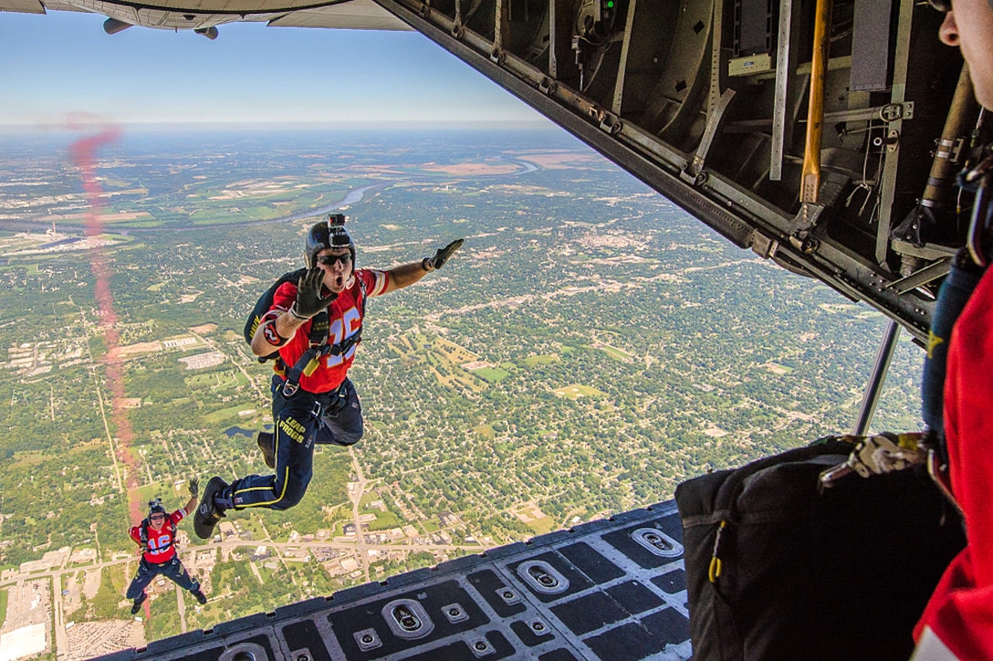 Two members of the U.S. Navy Parachute Demonstration Team, the Leap Frogs, jump out of a C-130 Hercules aircraft into Arrowhead Stadium for the Kansas City Chiefs versus San Diego Chargers salute to service members football game in Kansas City, Missouri, Sept. 11, 2016. Air National Guard photo by Senior Airman Sheldon Thompson