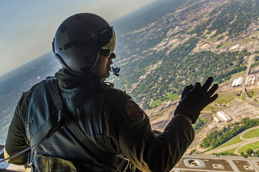 An airman gives the hand signal for members of the U.S. Navy Parachute Demonstration Team, the Leap Frogs, to jump out of a C-130 Hercules aircraft into Arrowhead Stadium for the Kansas City Chiefs versus San Diego Chargers salute to service members football game in Kansas City, Missouri, Sept. 11, 2016. Air National Guard photo by Senior Airman Sheldon Thompson