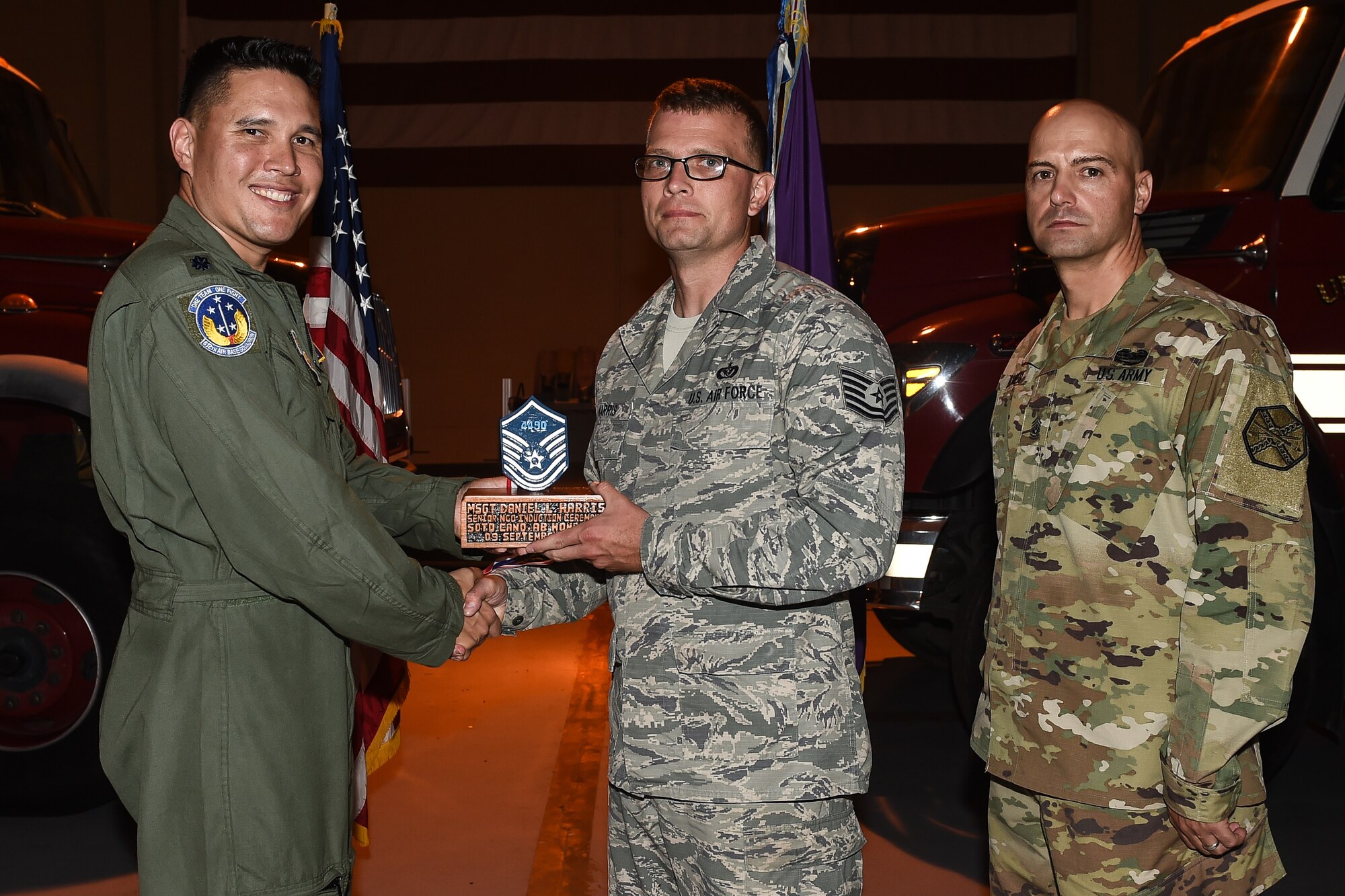 U.S. Air Force Tech. Sgt. Daniel L. Harris (center), 612th Air Base Squadron engineering superintendent of the planning section, poses for a photo with Lt. Col. David Aragon, 612th ABS commander, and U.S. Army Cmd. Sgt. Maj. Robin Bolmer, Army Support Activity command sergeant major, during the first senior non-commissioned officer induction ceremony held at Soto Cano Air Base, Honduras, Sept. 9, 2016. Harris was raised in Newport News, Va., and joined the Air Force in 2004.
