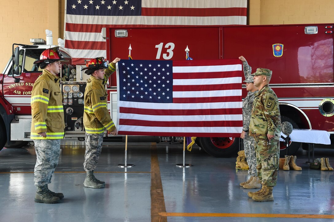 Members of Joint Task Force-Bravo’s Fire Emergency Services and Joint Security Forces prepare to fold an American flag in honor of the emergency services personnel who lost their lives during the terrorist attacks of Sept. 11, 2001, during the 9/11 remembrance ceremony at Soto Cano Air Base, Honduras, Sept. 9, 2016. After the flag was folded, it was laid to rest on the ceremony's emergency services monument, and rendered a salute to honor the fallen heroes.
