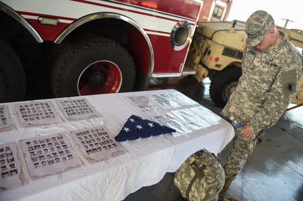 A member of Joint Task Force-Bravo looks at the emergency services monument set up for the 9/11 remembrance ceremony at Soto Cano Air Base, Honduras, Sept. 9, 2016. Pictures of the 447 first responders who lost their lives during the terrorist attacks of Sept. 11, 2001 were displayed on the monument.