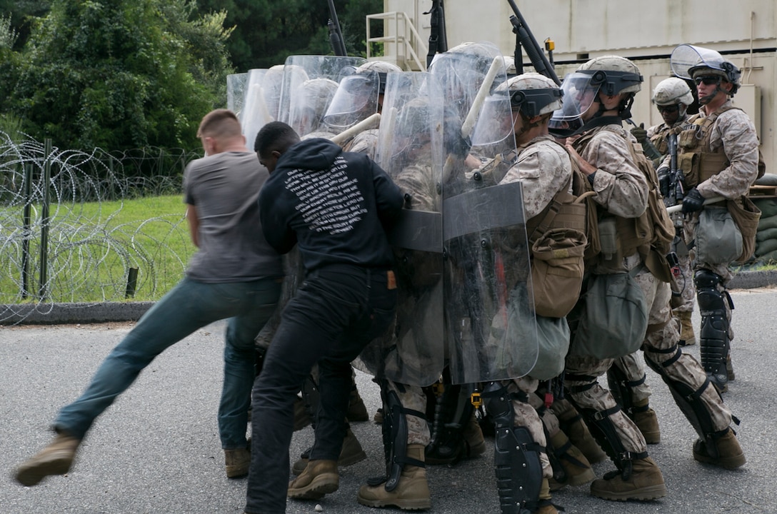 Marines from Fleet Anti-Terrorism Security Team, Marine Corps Security Force Regiment, repel role players with riot shields from entering during an embassy security exercise at Naval Expeditionary Combat Center, Naval Weapons Station Yorktown, Va., Sept. 8, 2016.
	The Marines conducted their exercise from Sept. 6- 8, testing their ability to reinforce an embassy in a foreign nation while maintaining site security, conducting convoy operations, properly establishing vehicle checkpoints, non-lethal weapons training and riot control tactics.
	“We have to get out the kinks that we have, that way we’re ready to deploy at any time,” said Cpl. Timothy Blackburn, 3rd Platoon, Company C, FAST, MCSFR. “The training is good, but it is stressful at times with the situations that are thrown at you.” 
	The Marines will continue to conduct pre-deployment training over the next four months before deploying to Bahrain to continue the mission of providing security in foreign countries.
