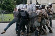 Marines from Fleet Anti-Terrorism Security Team, Marine Corps Security Force Regiment, repel role players with riot shields from entering during an embassy security exercise at Naval Expeditionary Combat Center, Naval Weapons Station Yorktown, Va., Sept. 8, 2016.
	The Marines conducted their exercise from Sept. 6- 8, testing their ability to reinforce an embassy in a foreign nation while maintaining site security, conducting convoy operations, properly establishing vehicle checkpoints, non-lethal weapons training and riot control tactics.
	“We have to get out the kinks that we have, that way we’re ready to deploy at any time,” said Cpl. Timothy Blackburn, 3rd Platoon, Company C, FAST, MCSFR. “The training is good, but it is stressful at times with the situations that are thrown at you.” 
	The Marines will continue to conduct pre-deployment training over the next four months before deploying to Bahrain to continue the mission of providing security in foreign countries.
