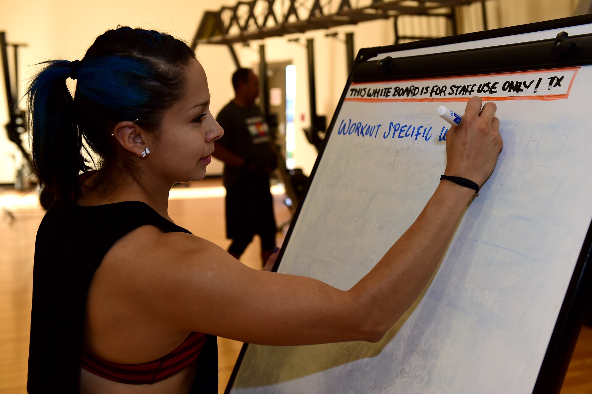 Azul Farrera, 460th Force Support Squadron recreation assistant, writes a workout plan for her class Sept. 9, 2016, at the Buckley Fitness Center on Buckley Air Force Base, Colo. The fitness center provides personal training at no cost to active duty service members. (U.S. Air Force photo by Airman 1st Class Gabrielle Spradling/Released)