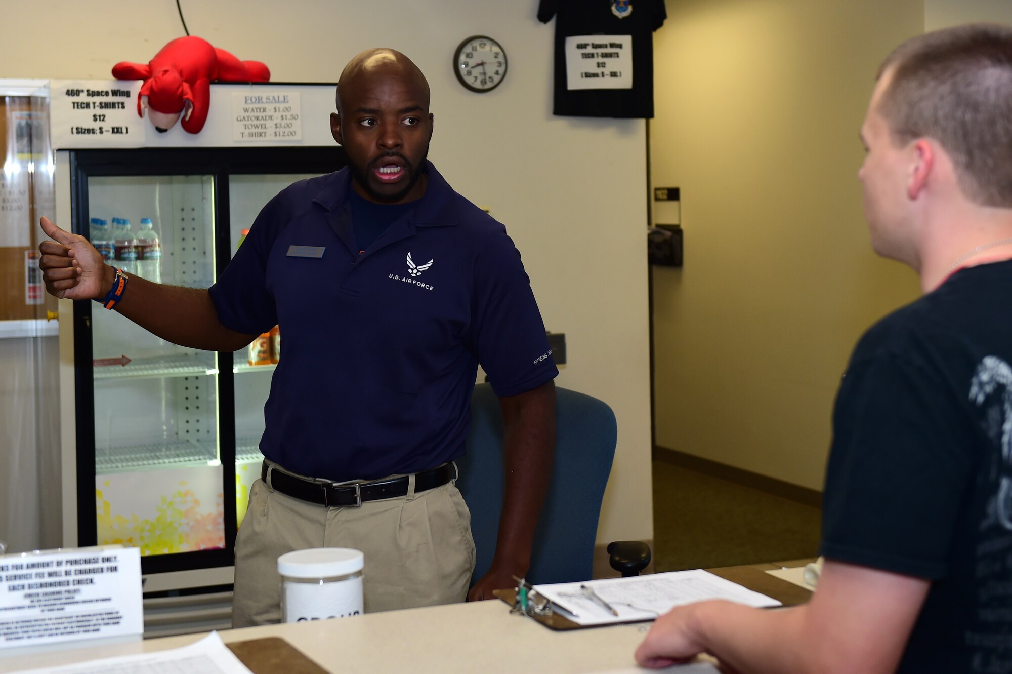 Jionni Paige, 460th Force Support Squadron recreation assistant, helps a fitness center patron Sept. 9, 2016, at the Buckley Fitness Center on Buckley Air Force Base, Colo. The fitness center provides a variety of workout options including treadmills, elliptical trainers, indoor track, stair steppers, racquetball courts and a multi-purpose room. (U.S. Air Force photo by Airman 1st Class Gabrielle Spradling/Released)