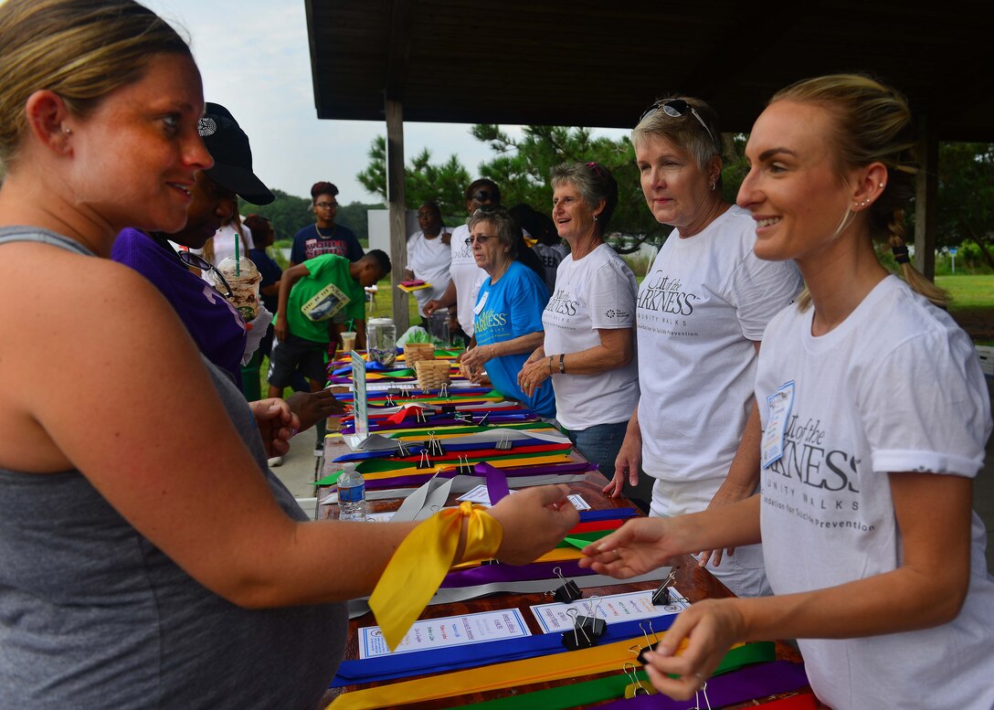 An Out of the Darkness Community Walk participant receives a yellow ribbon before the event at Mount Trashmore Park, Virginia Beach, Va., Sept. 10, 2016. A yellow ribbon signifies honor and remembrance of an extended family member that committed suicide or is a survivor. (U.S. Air Force photo by Tech. Sgt. Daylena S. Ricks)