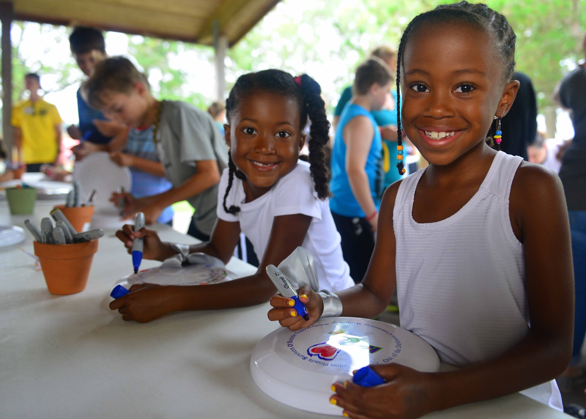 Gabriela Artis, 8, and sister, Giavanna Artis, 7, decorate Frisbees to celebrate, honor and remember victims and survivors of suicide during the Out ofthe Darkness Community Walk at Mount Trashmore Park, Virginia Beach, Va., Sept. 10, 2016.  To facilitate grieving, participants could also have the name of their loved one read during the program; wear a colored armband in remembrance; or hang their picture on the Memory Wall. (U.S. Air Force photo by Tech. Sgt. Daylena S. Ricks)