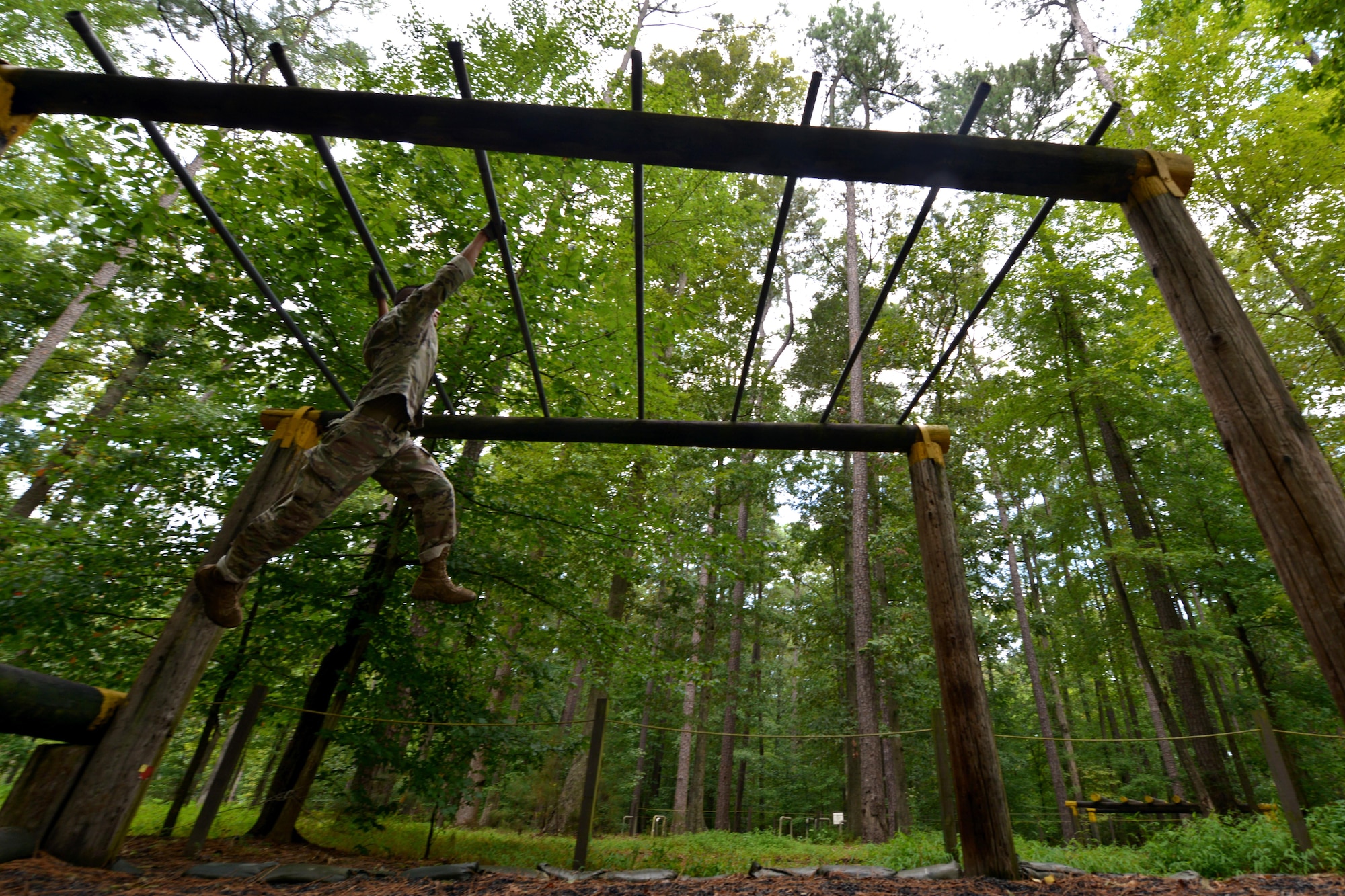 U.S. Army Spc. Huy Trihn, 155th Inland Cargo Transport Company wheeled vehicle mechanic, swings through the monkey-bar obstacle at the obstacle course on Joint Base Langley-Eustis, Va., September 8, 2016.  The monkey bars are the final obstacle on the course, making it a challenge many participants struggle through. (U.S. Air Force photo by Staff Sgt. Natasha Stannard)