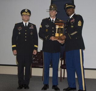 Maj. Gen. Anthony C. Funkhouser (right) and Command Sgt. Maj. Michael L. Gragg, (left) the Commanding General and Command Seargent Major for the Center for Initial Military Training present drill Sgt. Ryan Moldovan, an Army Reserve drill seargent with E Co. 1st. Battalion, 390th Infantry Regiment, 4th Brigade, 98th Training Division, 108th Training Command (IET) with the Army Reserve Component Drill Seargent of the Year trophy. The Drill Seargent of the Year competition where drill seargents from both the active and reserve components was held at Fort Jackson, S.C. from Sept. 6 through Sept. 9 and tested the competitors in a variety of Soldier tasks and drills such as the Army Physical Fitness Test, weapons knowledge and marksmanship as well as a timed 12 mile road march carrying a basic combat load and weapon. (U.S. Army Photo by Sgt. Javier Amador)