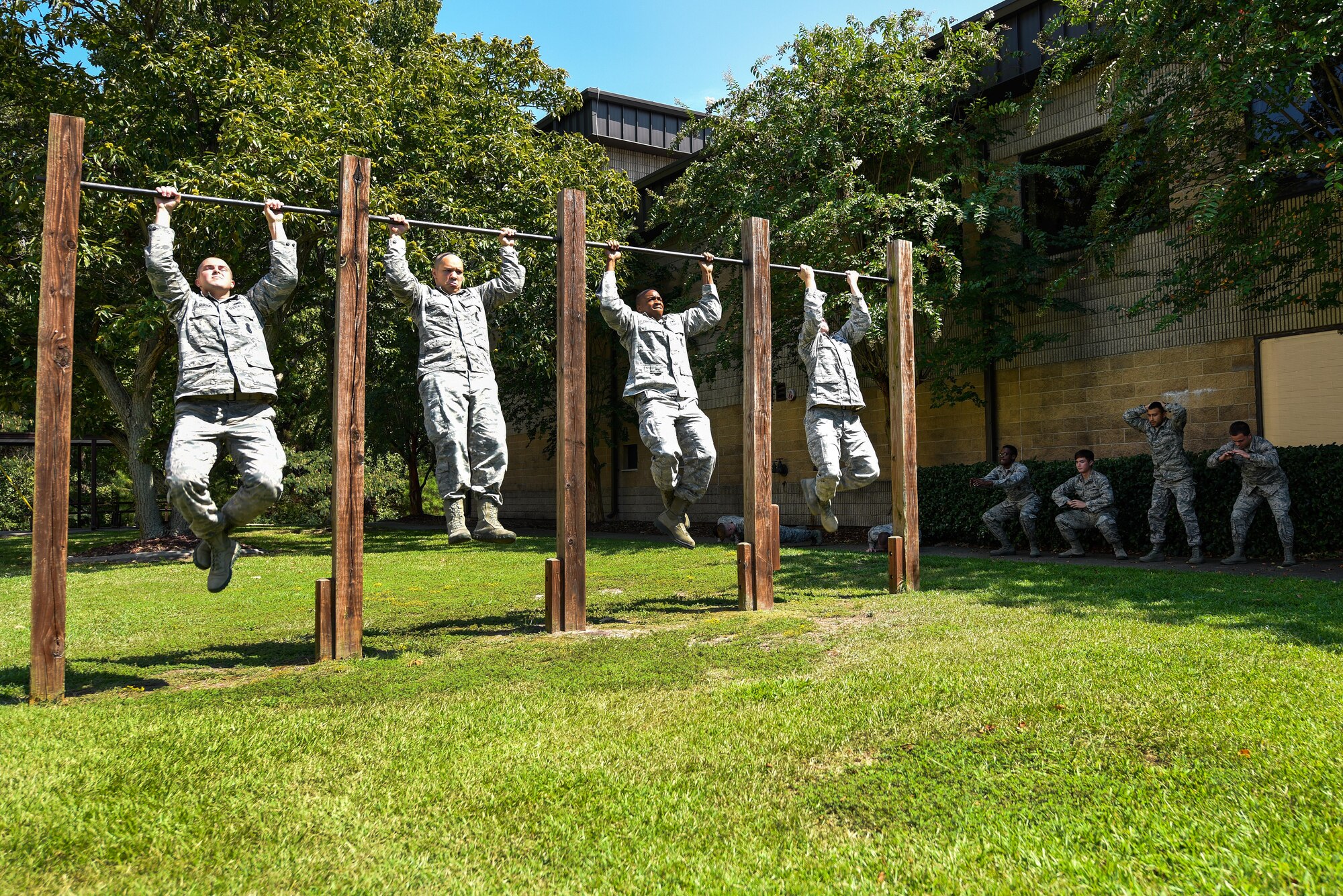 Four Airmen assigned to the 4th Security Forces Squadron perform pullups as part of a 10-minute exercise warm-up, Sept. 9, 2016, at Seymour Johnson Air Force Base, North Carolina. Airmen from the 4th SFS were selected to complete a seven-day training program to become certified combative basic instructors. (U.S. Air Force photo by Airman Shawna L. Keyes)