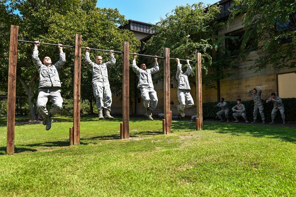 Four Airmen assigned to the 4th Security Forces Squadron perform pullups as part of a 10-minute exercise warm-up, Sept. 9, 2016, at Seymour Johnson Air Force Base, North Carolina. Airmen from the 4th SFS were selected to complete a seven-day training program to become certified combative basic instructors. (U.S. Air Force photo by Airman Shawna L. Keyes)