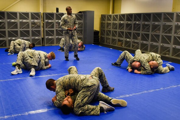 Tech. Sgt. Franklin Mosley (standing), 633rd Security Forces Squadron combative training instructor, teaches a group of defenders from the 4th SFS, Sept. 9, 2016, at Seymour Johnson Air Force Base, North Carolina. Airmen completed seven 10-hour days of instruction in combative training to become certified basic instructors. (U.S. Air Force photo by Airman Shawna L. Keyes)