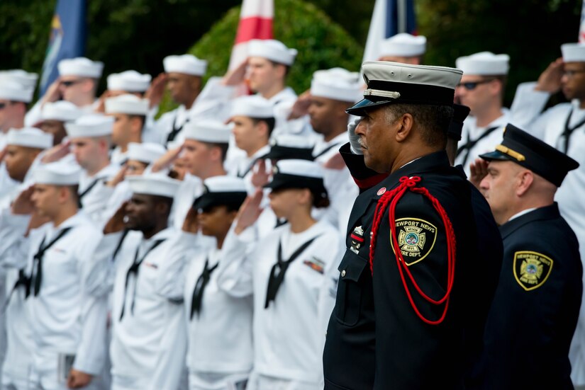 U.S. Navy Sailors and Newport News firefighters salute during the national anthem at a 9/11 memorial ceremony at the Victory Arch in Newport News, Va., Sept. 11, 2016.  The event served to honor the 2,977 people who lost their lives in the 2001 attacks on the World Trade Center, the Pentagon and United Airlines Flight 93. (U.S. Air Force photo by Staff Sgt. J.D. Strong II)