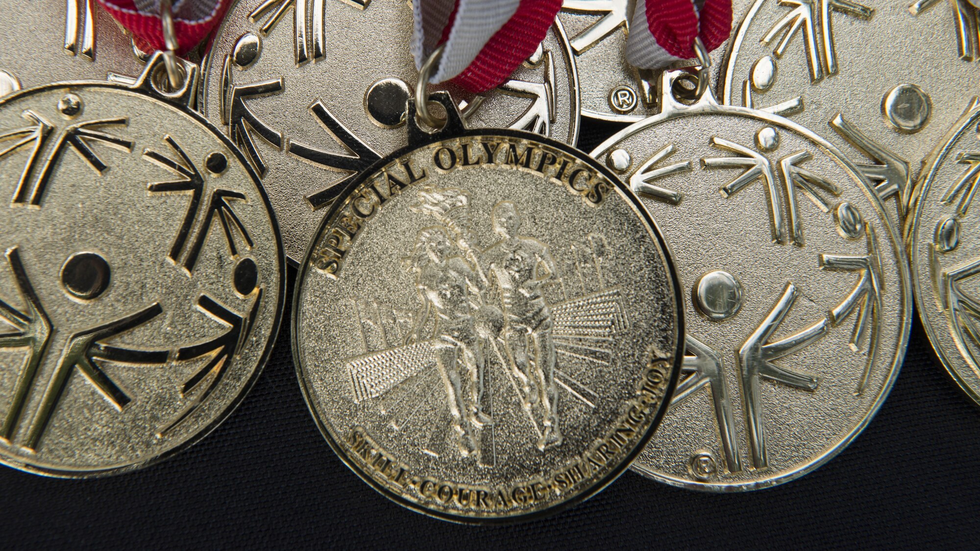 Special Olympic Gold Medals sit on display during the Special Olympics Delaware 2016 Cycling Classic Sept. 10, 2016, at Dover Air Force Base, Del. Gold, silver and bronze medals were presented to the 1st, 2nd and 3rd place finishers of each race. (U.S. Air Force photo by Senior Airman Zachary Cacicia)
