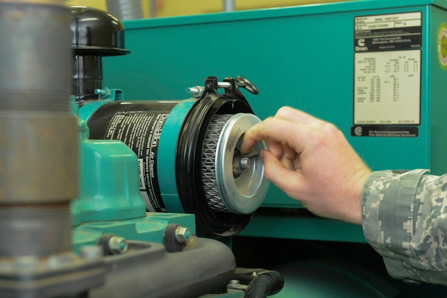 An Airman from the 5th Civil Engineer Squadron electrical power production shop checks an air filter during a pre-operation inspection at Minot Air Force Base, N.D., Sept. 12, 2016. The inspection includes checking the diesel fuel, coolant and oil levels. (U.S. Air Force photo/Airman 1st Class Jessica Weissman) 