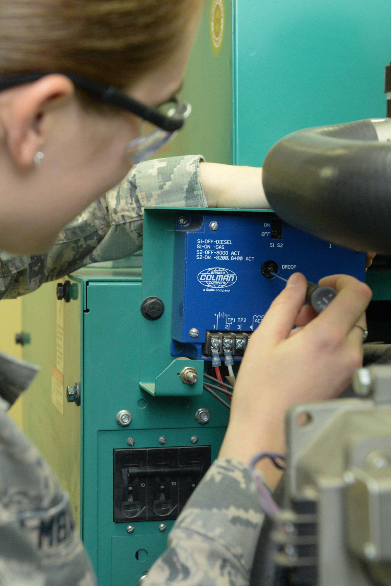 An Airman from the 5th Civil Engineer Squadron electrical power production shop adjusts the sensitivity of a generator at Minot Air Force Base, N.D., Sept. 12, 2016. Adjusting sensitivity allows the generator to run at a steady rate and react to the proper output load. (U.S. Air Force photo/Airman 1st Class Jessica Weissman)