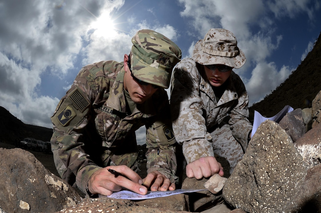 U.S. Army Cpl. Gregory McLellan and U.S. Marine Corps Cpl. Clinton Smith plot grid points during a joint training exercise at Arta, Djibouti. Through informal methods like training exercises, as well as formally established joint forums, the services  work together to share new technology and ideas to develop, test and deliver ever-better capabilities for Marines and Soldiers.  (U.S. Air Force photo by Tech. Sgt. Dan DeCook)