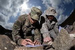 U.S. Army Cpl. Gregory McLellan and U.S. Marine Corps Cpl. Clinton Smith plot grid points during a joint training exercise at Arta, Djibouti. Through informal methods like training exercises, as well as formally established joint forums, the services  work together to share new technology and ideas to develop, test and deliver ever-better capabilities for Marines and Soldiers.  (U.S. Air Force photo by Tech. Sgt. Dan DeCook)